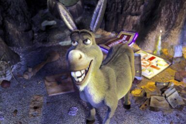 Animated donkey character smiling in a cluttered cave with scattered junk on the ground and walls behind him