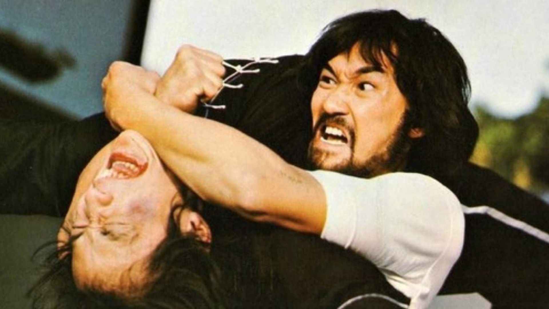 Two Men Grappling in a Heated Struggle One Grips the Other's Neck with a Tight Arm Lock Both Faces Strained with Effort Outside