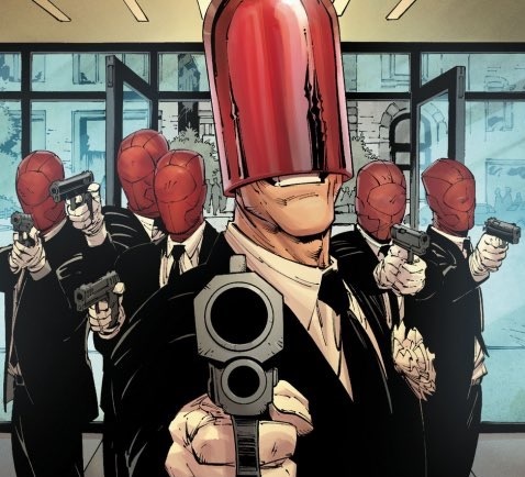First Look at Batman and the Leader of the Red Hood Gang in Dynamic Duo Were Shown Group of Men in Black Suits with Red Helmets Aiming Pistols at the Viewer Foregrounded by a Man Holding a Large Gun