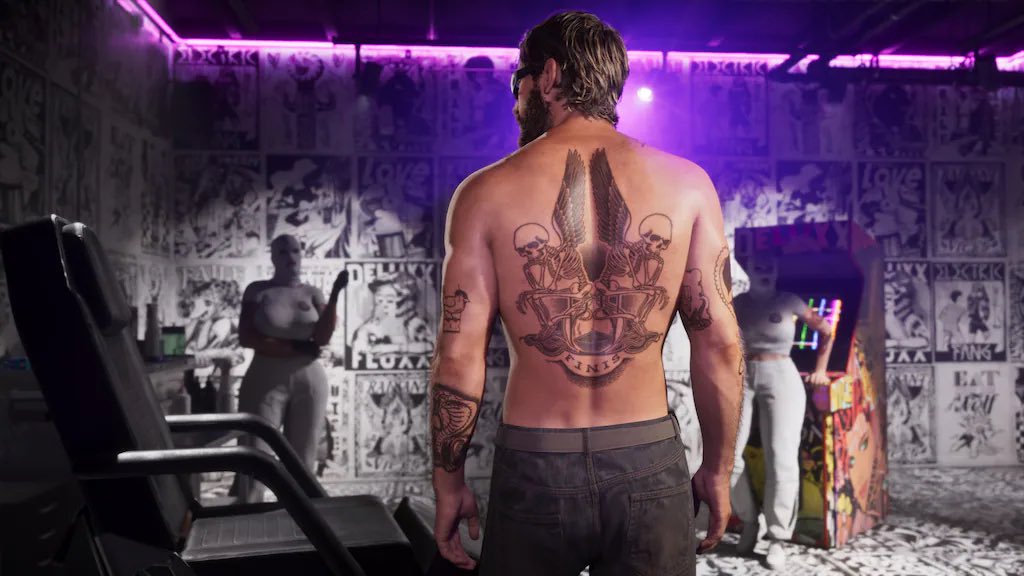 Back View of a Shirtless Man with a Large Back Tattoo Standing in a Purple Neon Graffiti covered Club