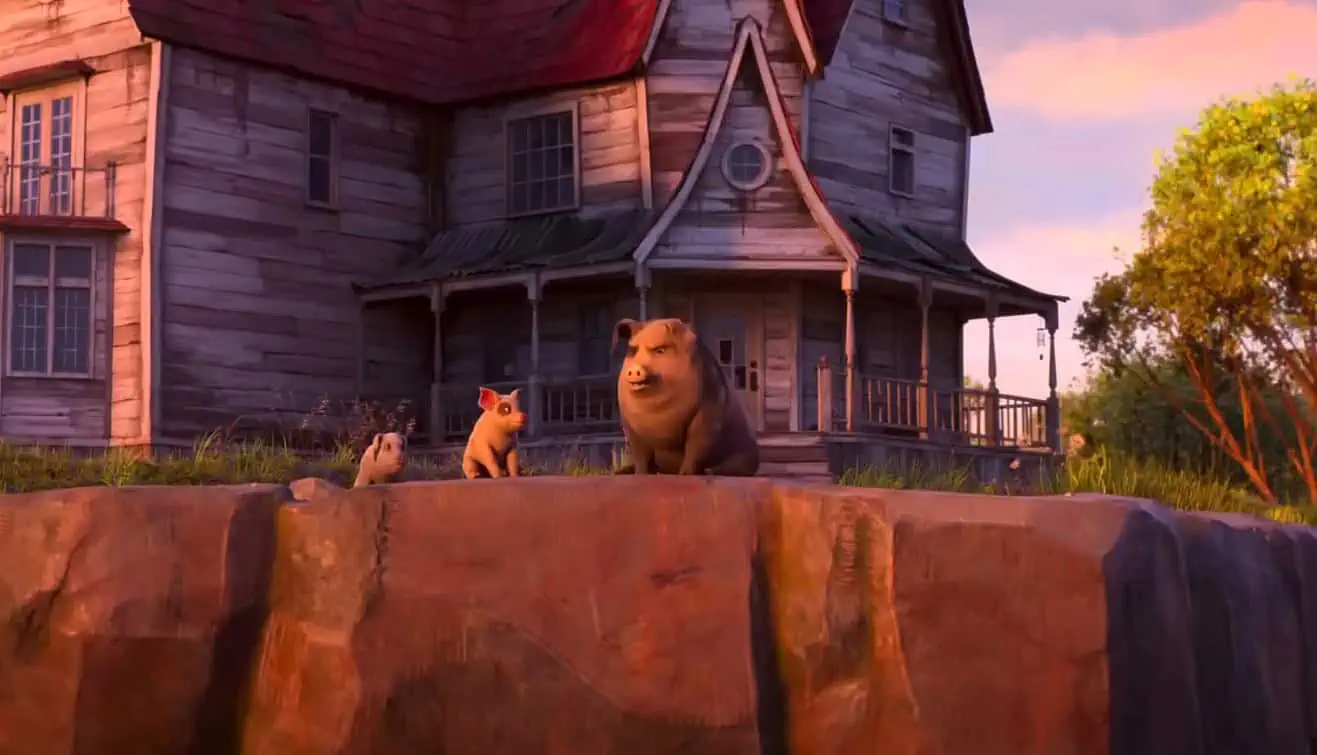 a Large Bear and Two Cubs Sit on a Rocky Ledge in Front of a Weathered Wooden House at Sunset