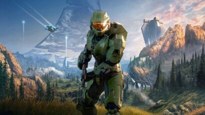 a Green Armored Soldier Crouches with a Rifle in a Rugged Valley Futuristic Structures Visible in the Distance Under a Blue Sky