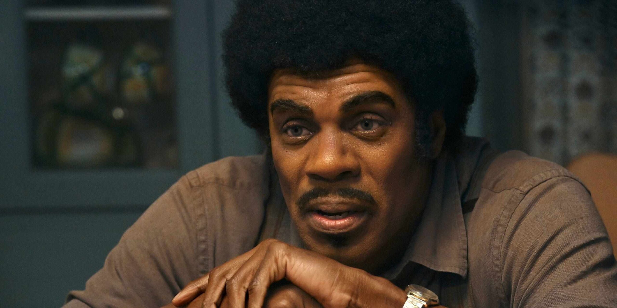 Mv5byjhhoge2zdytndu3yi00oguyltk2mgitotezmguwmmq3ytkyxkeyxkfqcgc v1 compressed Close up of a Man with a Large Afro Leaning on Folded Hands and Looking Thoughtful