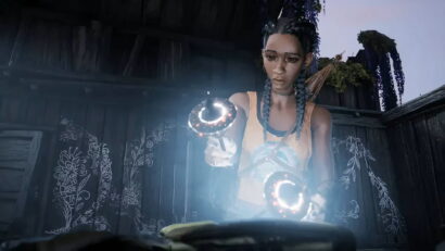 A woman with braided hair in an orange top points a glowing circular device toward the camera in a dim wooden room.
