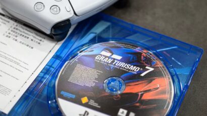 Gran Turismo 7 game disc in a blue case with a printed manual nearby.