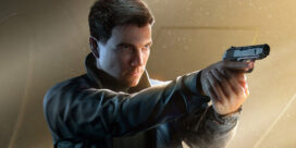 Man in a dark jacket aims a handgun with a focused expression, pointing to the right in a dramatic background.